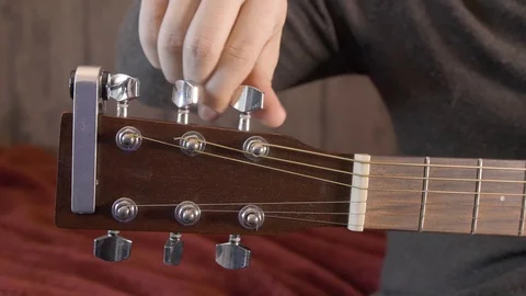 Close up of tuning a left hand acoustic guitar Stock Footage 130151837
