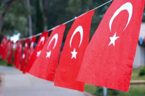Close up Turkish red flags hanging on a rope in a park Stock Photos