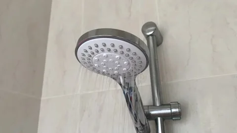 Close-up of turning on and off shower head in bathroom, white tiles with pink pa Stock Footage 201605984