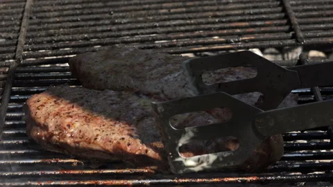 Close up on turning a beef steak on the grill 4K Vídeo Stock 130874356