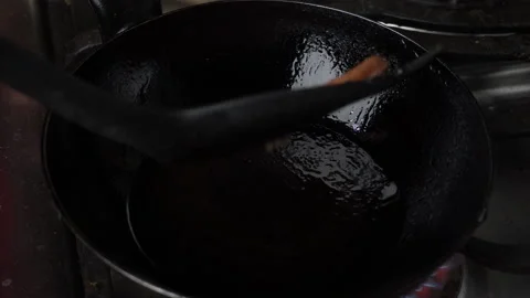 Close-up turning a hamburger that is being fried in a pan in the kitchen Vidéo 141055059