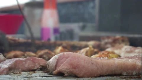 Close-up turning various grilled meats with a tong from a barbecue set on the Stock Footage 178463501
