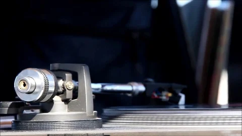 Close Up Turntable Arm with a Vinyl Record Bending with the Warmth of the Sun Stock Footage 77835977