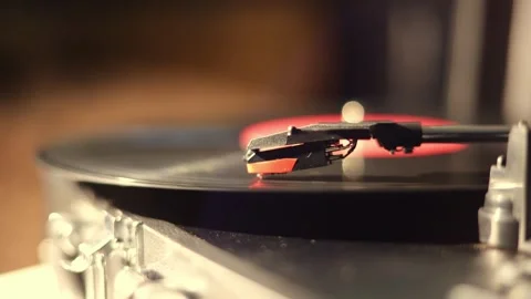 Close-up of a turntable needle playing a vinyl record with warm lighting Stock Footage 337104440