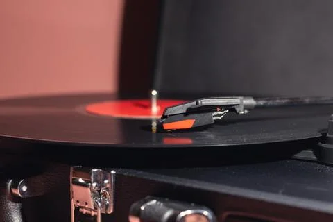 Close-up of a turntable needle playing a vinyl record with a red label 库存照片