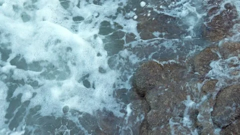 Close-Up Turquoise Sea Breaking Over Dark Coastal Rocks Stock Footage 322055831