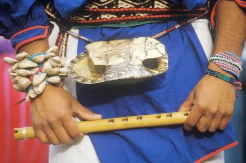 Close-up of turtle shell worn on the waist of a man holding flute during Corn Fotos de archivo