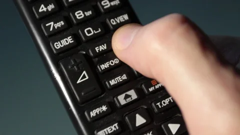 Close-up, TV remote control in the hands of a man while changing channels Stock Footage 120737665