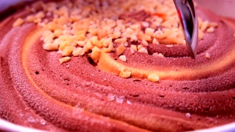 Close-up of twisted chocolate-caramel ice cream is picked up on a spoon Stock Footage 134910802