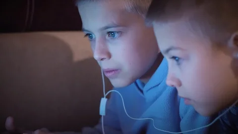 Close Up of two 10 - 13 years old brothers watching a movie on laptop Stock Footage 101028783
