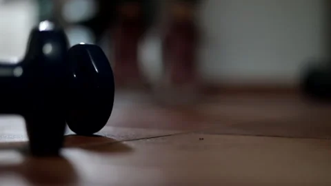 Close-up of two 2 kg weights and a sportswoman doing gymnastics at home. Stock Footage 243826680