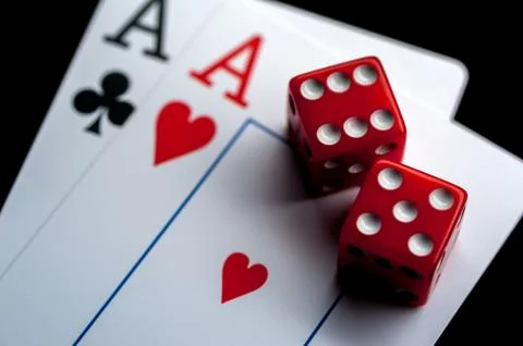 Close-up - Two aces, playing cards and red gaming dices on black table. Stock Photos