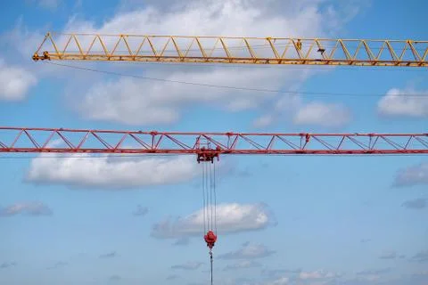 Close-up of two arrows of construction cranes arranged in parallel against a  Stock Photos