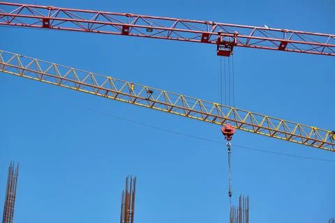 Close-up of two arrows of construction cranes arranged in parallel against a  Stock Photos