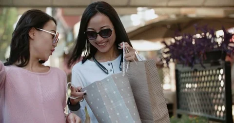 Close-up of two Asian girls attractive girls after a day of shopping with a Stock Footage