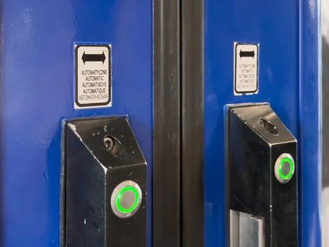 Close-up of two automatic door entry systems with illuminated green buttons.. Stock Photos