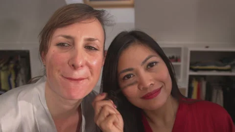 CLOSE UP: Two beautiful women using beauty products for applying face make up Vidéo 202105961