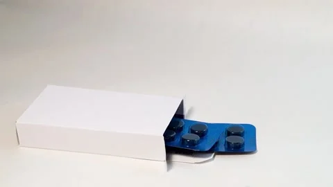 Close-up. Two blue pill blisters stick out of the box on a white background Video stock 178095914
