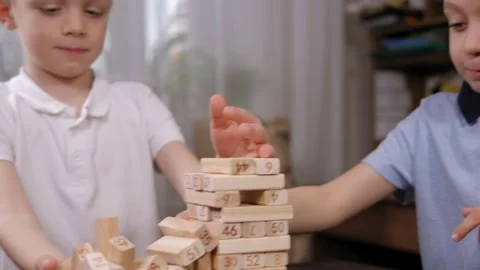 Close-up of two boys playing an exciting board game with wooden cubes. Stock Footage 329275952