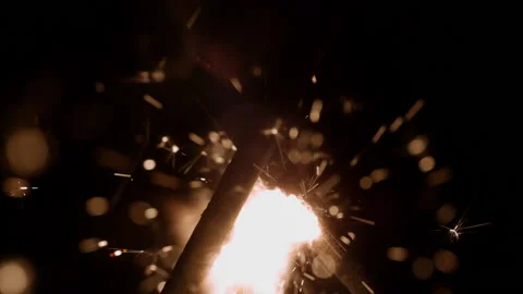 Close-up Of Two Burning Sparklers Against A Dark Background Stock Footage 233460050