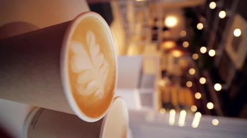 Close up two cardboard coffee cups take away on table over bokeh background - Stock Footage 224366579