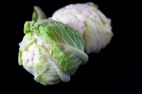Close up of two Cauliflower cabbage heads on black background Stock Photos