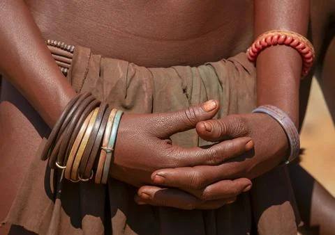 Close-up of two clasped hands adorned with colorful beaded and rubber brace.. Stock Photos