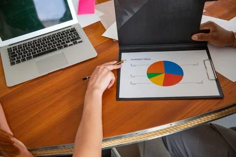 Close-up of two colleagues' hands analyzing a financial graph 库存照片