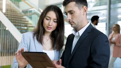 Close up of Two Creative Team Leaders Using PC Tablet while Discussing Project Stock Footage 112012822