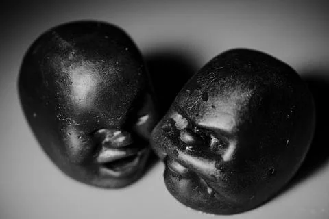 A close-up of two dark, sculptural faces placed face to face. Stock Photos