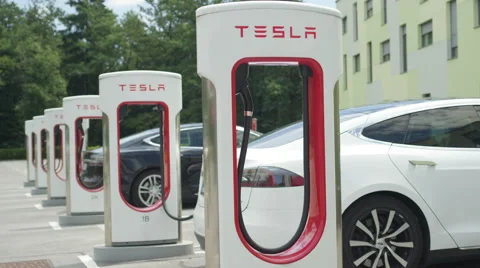 CLOSE UP: Two electric cars parked and recharging batteries at Tesla charger Stock Footage
