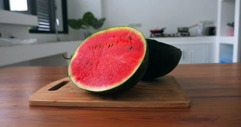 Close-up of two equal halves of a ripe organic green watermelon on a wooden Stock Footage 219443797