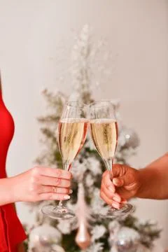 Close of of a two female hands doing a toast with champagne glass Stock Photos
