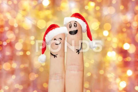 Close up of two fingers with smiley and santa hats Stock Photos