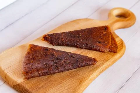 Close up of two folded dark brown triangular fruit pastille pieces resting .. Stock Photos