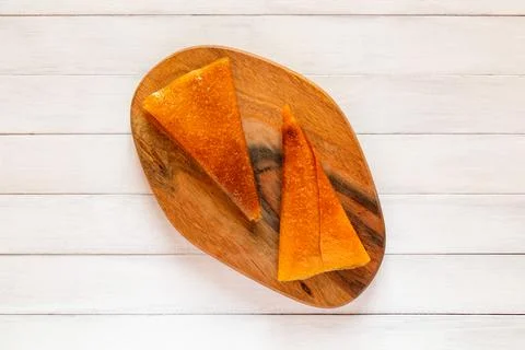 Close up of two folded orange triangular fruit pastille pieces resting on d.. Stock Photos