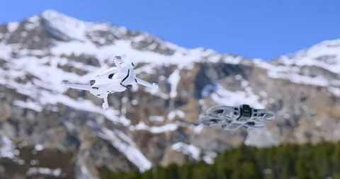 Close Up of Two FPV Drones Flying in Snowy Mountains Stock Footage 346756020