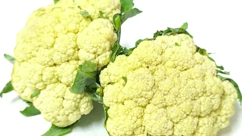 Close-up of two fresh raw cauliflower heads isolated on white background. 스톡 동영상 338990809