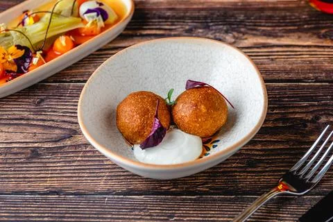 Close-up of two fried croquettes served with creamy dip Stock Photos