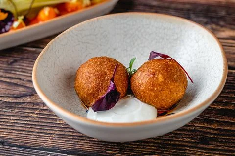 Close-up of two fried croquettes served with creamy dip Stock Photos