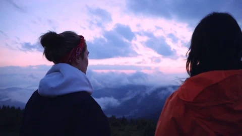 Close-up two friendly girls observing mountain scenery pointing with finger Video stock 114318549
