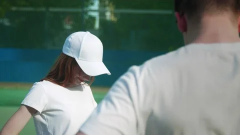 Close-up of two girls and a guy on a tennis court. Warm-up Stock Footage 221762260