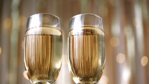 Close up two glasses champagne on defocused background festive lights. low angle Video stock 263027792