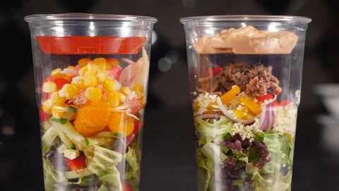 Close-up of two glasses in which fresh salads with two sauces. Stock Footage 128293308