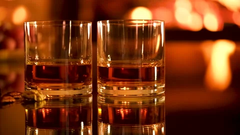 Close-up. Two glasses with whiskey and serving on the fireplace background. Stock Footage 166394853