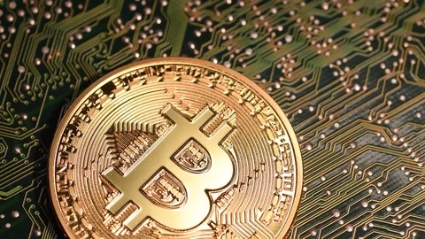Close-up of two gold bitcoin physical coins on electronic circuit. Stock Footage 88505732