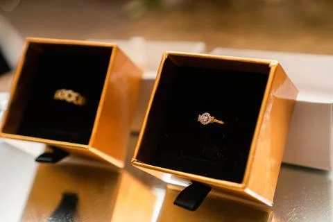 Close-up of two gold rings inside golden boxes. Birthday or Wedding Favors Stock Photos