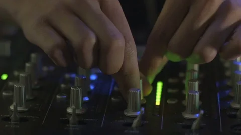 Close up of two hands adjusting knobs and pushing buttons a mixing board Stock Footage 72081764