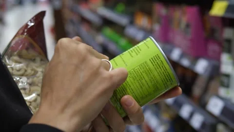 Close up of two hands holding canned product to read ingredients details in Stock-Footage 141445857