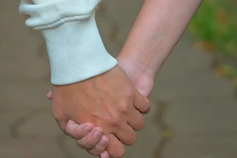 Close-up of two hands of mom and daughter holding together Stock Photos